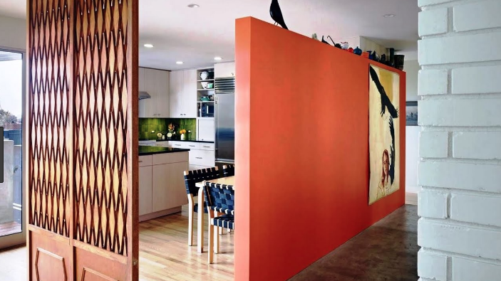 Orange innervägg som skiljer av ett kök